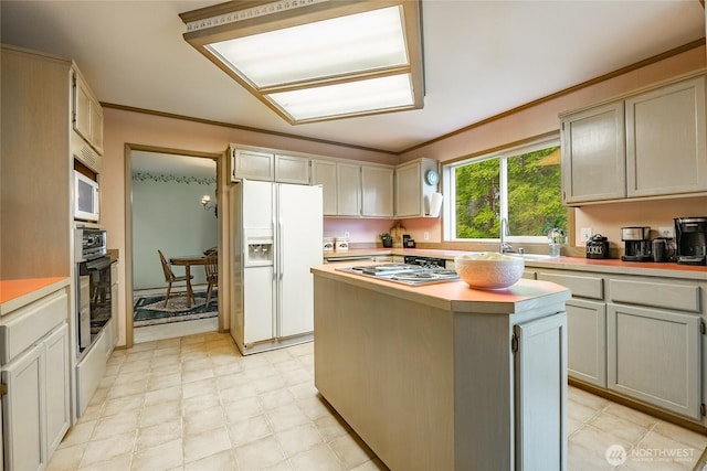 1117 W Racine St, Bellingham, WA 98229 - kitchen with white appliances, a sink, light countertops, a kitchen island, and crown molding