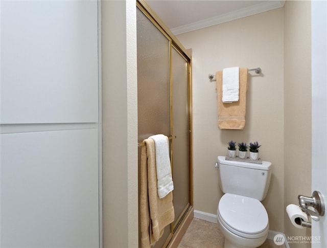 full bath featuring a shower stall, crown molding, toilet, tile patterned floors, and baseboards