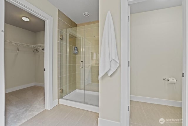 733 222nd Pl NE, Sammamish, WA 98074 - bathroom featuring a stall shower, a walk in closet, and baseboards