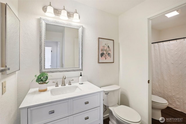 bathroom with toilet, vanity, wood finished floors, and a shower with curtain