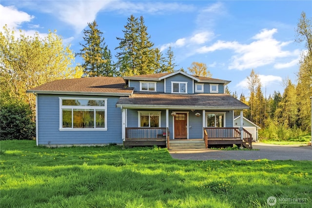 view of front facade featuring a porch, a front lawn, and an outdoor structure