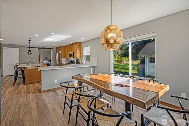dining space featuring healthy amount of natural light, light wood-style flooring, and recessed lighting