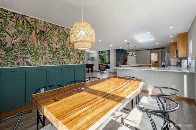 dining room with wood finished floors, recessed lighting, and wallpapered walls