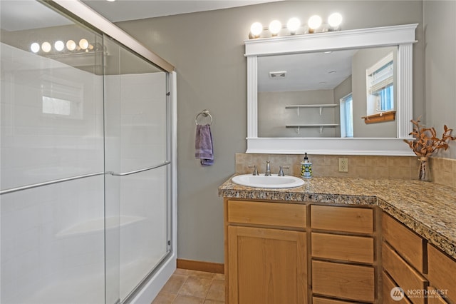 full bathroom with a shower stall, vanity, and backsplash
