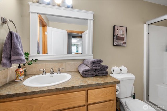 bathroom featuring vanity, an enclosed shower, and toilet