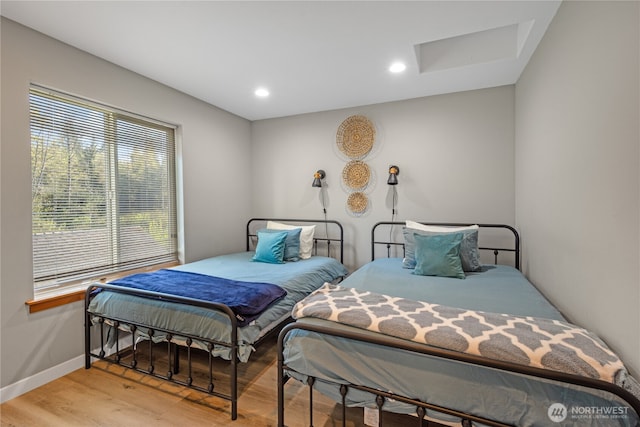 bedroom featuring light wood finished floors and baseboards