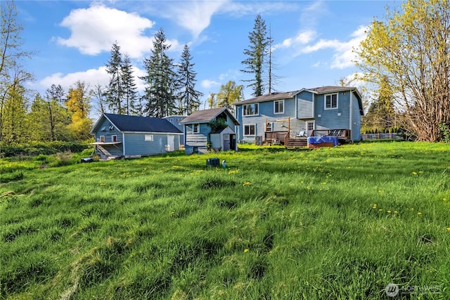 back of house with a shed, an outbuilding, and a deck