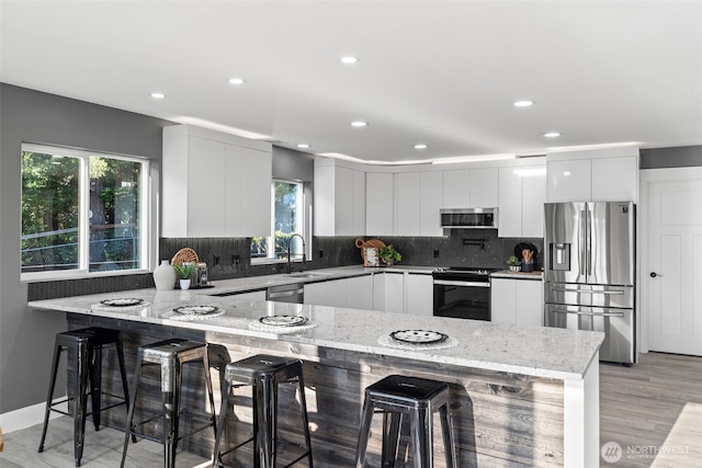 9371 Willamette Meridian Rd NW, Silverdale, WA 98383 - kitchen featuring appliances with stainless steel finishes, modern cabinets, a sink, a peninsula, and white cabinetry