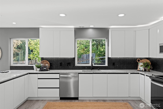 9371 Willamette Meridian Rd NW, Silverdale, WA 98383 - kitchen with appliances with stainless steel finishes, modern cabinets, a sink, white cabinets, and recessed lighting