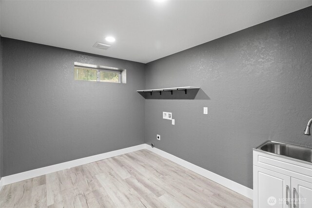 9371 Willamette Meridian Rd NW, Silverdale, WA 98383 - washroom with washer hookup, light wood-style floors, cabinet space, baseboards, and a textured wall