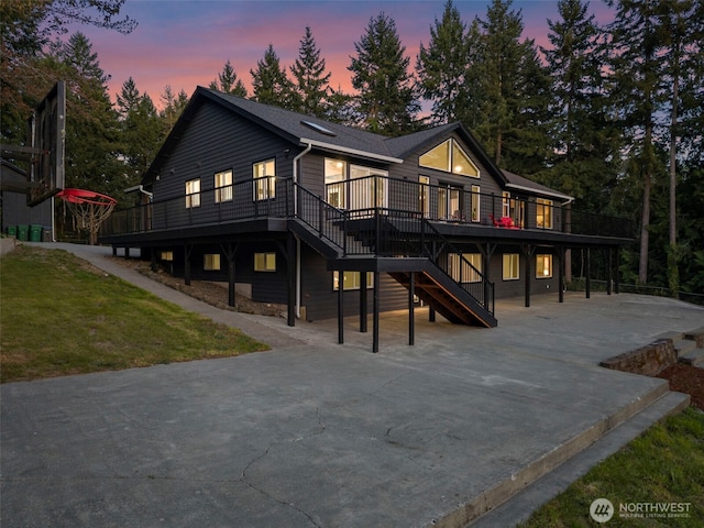 9371 Willamette Meridian Rd NW, Silverdale, WA 98383 - view of front facade with stairway, a wooden deck, a patio area, concrete driveway, and a front lawn