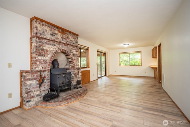 377 Stellar Ridge Ln, Sequim, WA 98382 - living room with a wood stove, light wood-style flooring, and baseboards