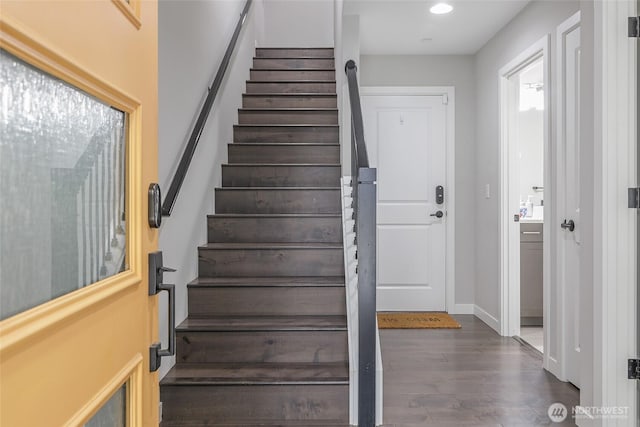 staircase featuring wood finished floors, baseboards, and recessed lighting