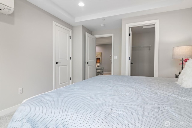 bedroom featuring an AC wall unit, baseboards, a closet, recessed lighting, and carpet floors