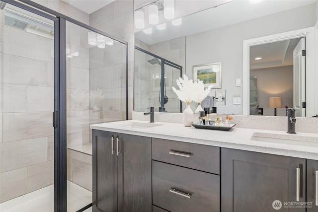 bathroom with a stall shower, double vanity, and recessed lighting