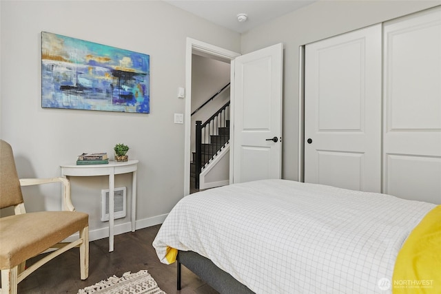 bedroom featuring baseboards, dark wood-style flooring, and a closet