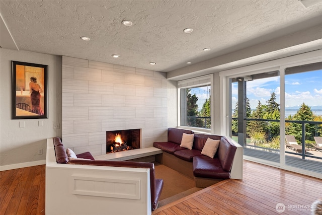 10326 66th Pl W, Mukilteo, WA 98275 - living area featuring a textured ceiling, baseboards, hardwood / wood-style flooring, a tile fireplace, and recessed lighting