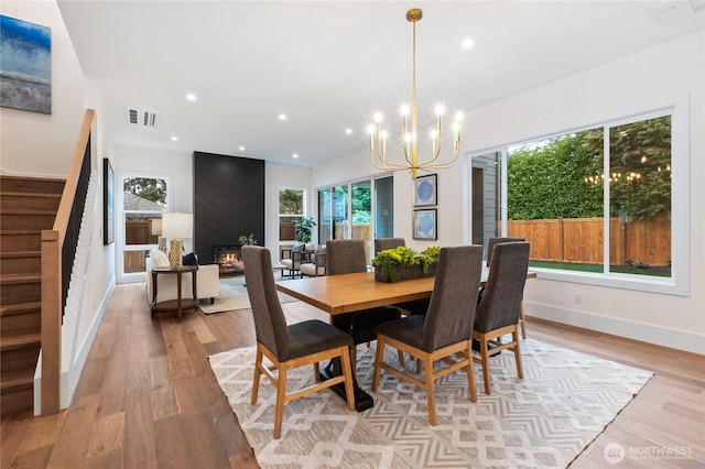 8232 21st Ave NE, Seattle, WA 98115 - dining space with stairs, a chandelier, plenty of natural light, light wood-style flooring, and recessed lighting