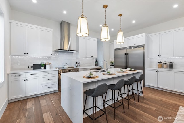 8232 21st Ave NE, Seattle, WA 98115 - kitchen featuring wall chimney range hood, appliances with stainless steel finishes, a sink, a kitchen bar, and backsplash