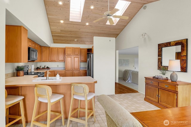 2847 Viewmont Pl, Camano Island, WA 98282 - kitchen with a skylight, wood ceiling, electric range, freestanding refrigerator, and recessed lighting