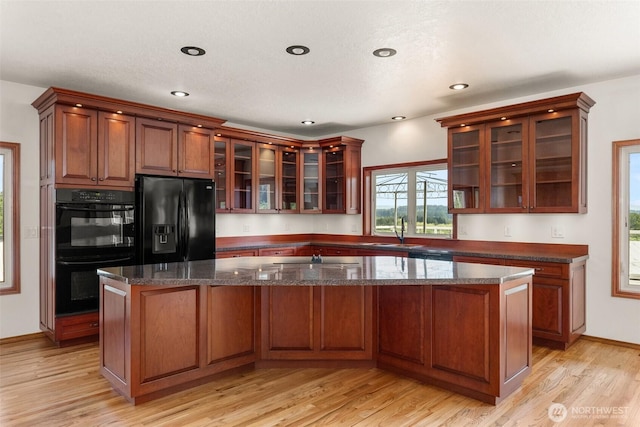 139 Coulson Rd, Chehalis, WA 98532 - kitchen featuring black appliances, a sink, light wood-type flooring, a center island, and glass insert cabinets
