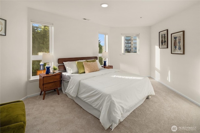 bedroom with light colored carpet and baseboards