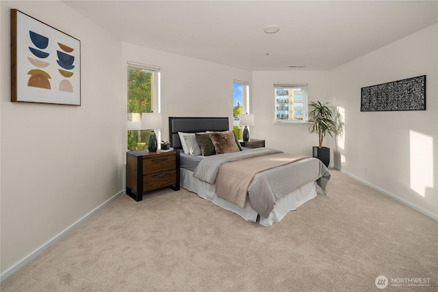 bedroom with light carpet and baseboards