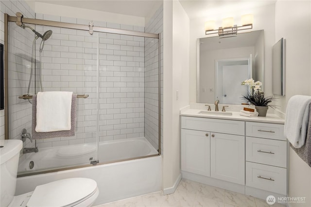 bathroom with toilet, marble finish floors, shower / bath combination with glass door, vanity, and baseboards