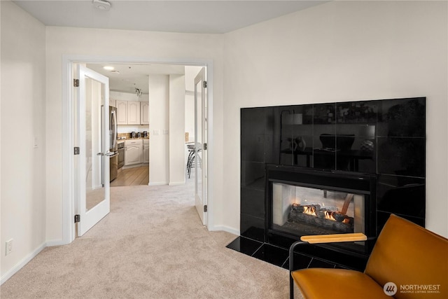 living room featuring light carpet and baseboards