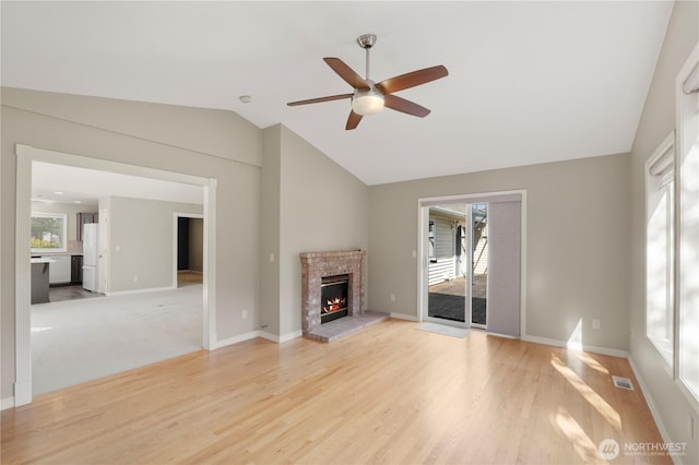 10308 139th Street Ct E, Puyallup, WA 98374 - unfurnished living room with ceiling fan, vaulted ceiling, a fireplace, light wood-style flooring, and baseboards