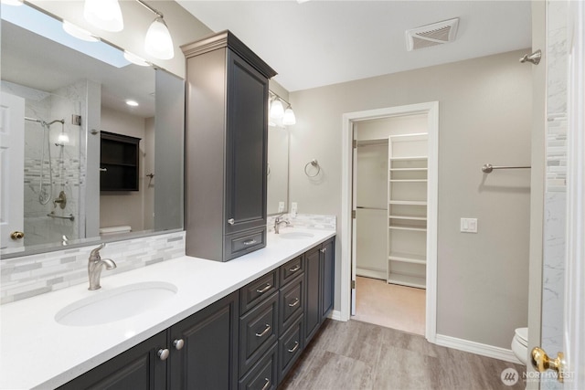 10308 139th Street Ct E, Puyallup, WA 98374 - full bath featuring toilet, an enclosed shower, wood finished floors, double vanity, and backsplash