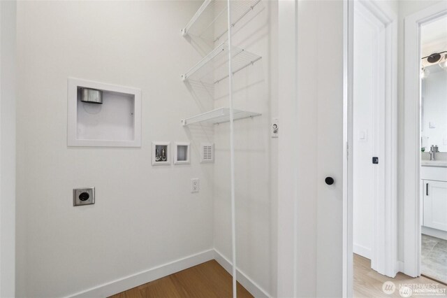 7741 15th Ave NE Unit B, Seattle, WA 98115 - laundry area featuring hookup for a washing machine, electric dryer hookup, light wood-style flooring, and baseboards