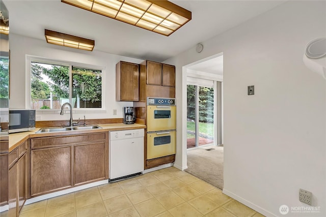 12416 SE 210th St, Kent, WA 98031 - kitchen featuring dishwasher, a sink, double oven, light tile patterned flooring, and light countertops