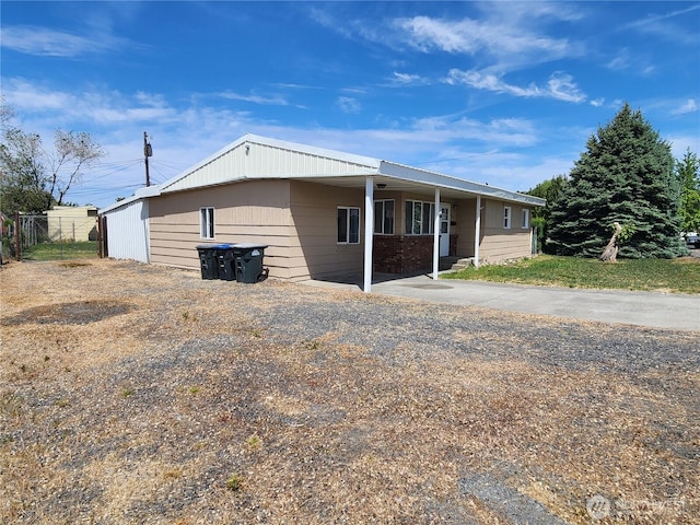 1476 W Sunset Dr, Moses Lake, WA 98837 - view of front of home with concrete driveway, an attached carport, and fence