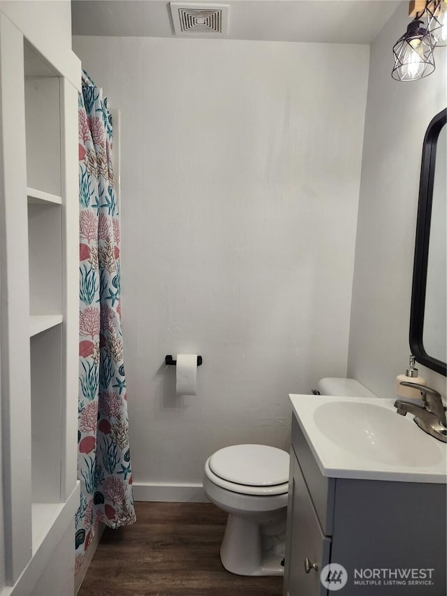 1476 W Sunset Dr, Moses Lake, WA 98837 - full bathroom with toilet, wood finished floors, vanity, a shower with curtain, and baseboards