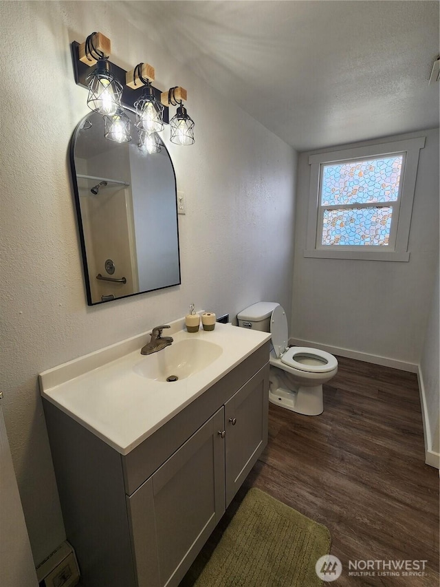 1476 W Sunset Dr, Moses Lake, WA 98837 - bathroom with wood finished floors, vanity, toilet, and baseboards