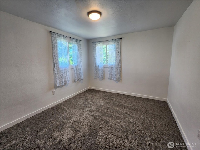 1476 W Sunset Dr, Moses Lake, WA 98837 - unfurnished room featuring dark colored carpet and baseboards