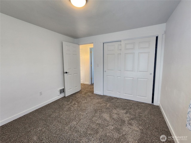 1476 W Sunset Dr, Moses Lake, WA 98837 - unfurnished bedroom featuring dark carpet, baseboards, and a closet