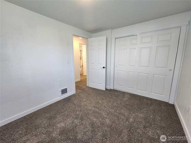 1476 W Sunset Dr, Moses Lake, WA 98837 - unfurnished bedroom with dark colored carpet, baseboards, and a closet