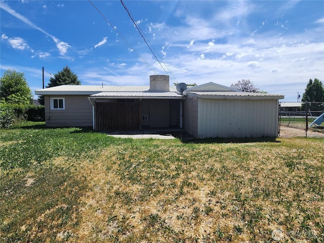 1476 W Sunset Dr, Moses Lake, WA 98837 - back of property with metal roof, a sunroom, and a chimney