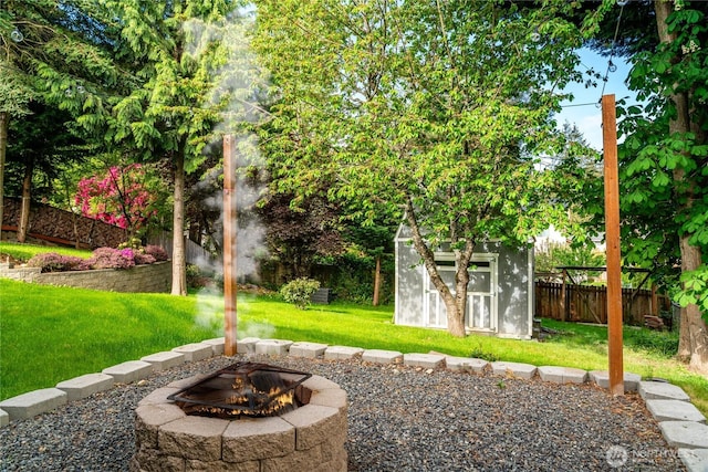 view of yard with a storage shed, an outdoor fire pit, and an outdoor structure