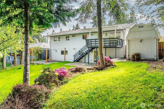 back of property featuring a deck, stairway, an outdoor structure, and a shed