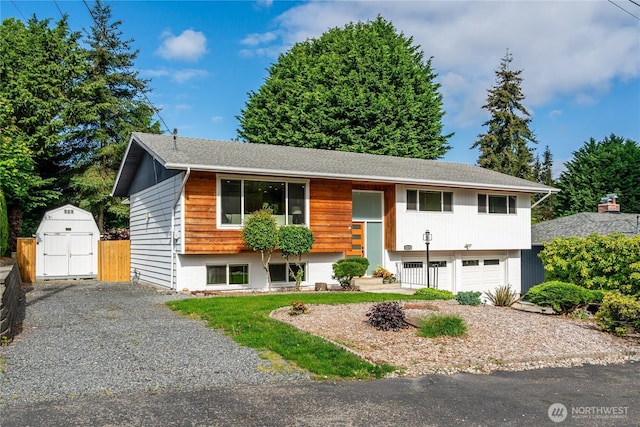 raised ranch featuring a storage unit, an attached garage, driveway, and an outdoor structure