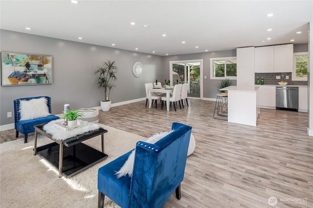 living room with light wood-style floors, recessed lighting, and baseboards