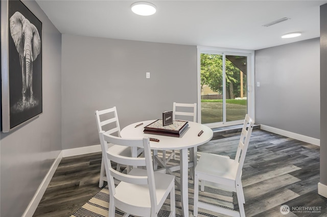 dining space with baseboards and wood finished floors