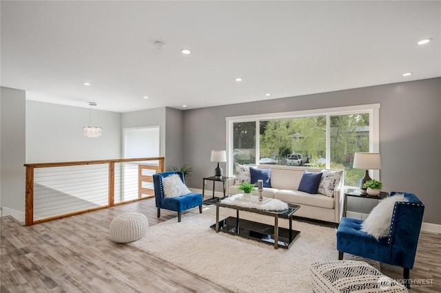 living room with wood finished floors, baseboards, recessed lighting, and a chandelier