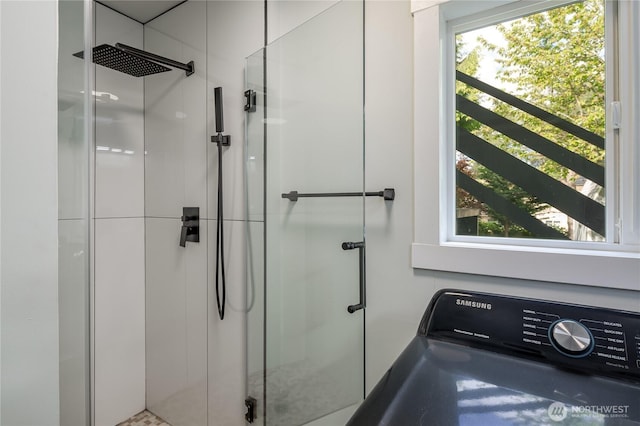 full bath with washer / dryer and a stall shower