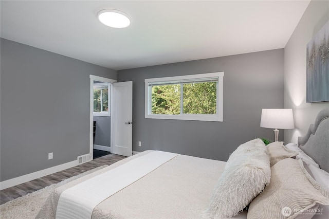 bedroom featuring wood finished floors and baseboards