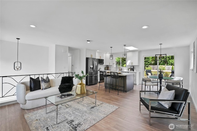 living room with light wood finished floors and recessed lighting