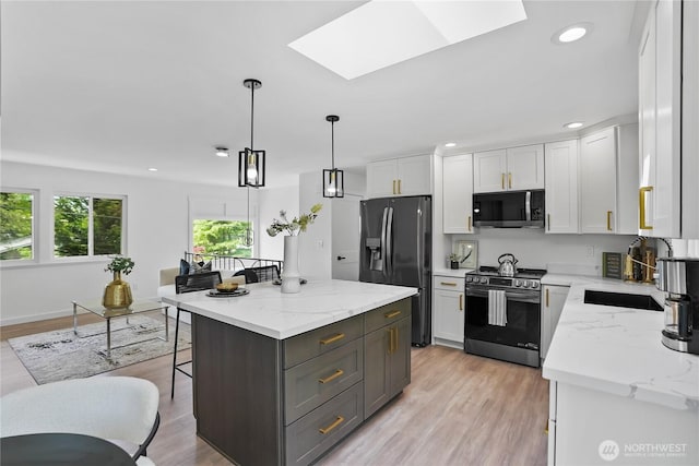 kitchen featuring stainless steel stove, black refrigerator with ice dispenser, a skylight, white cabinets, and a center island